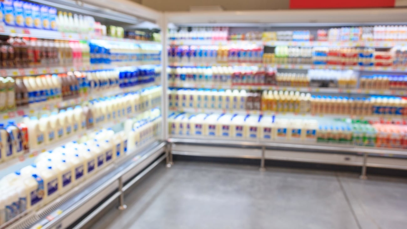 Defocused blur of supermarket shelves with dairy products. Blur background with bokeh. Defocused image