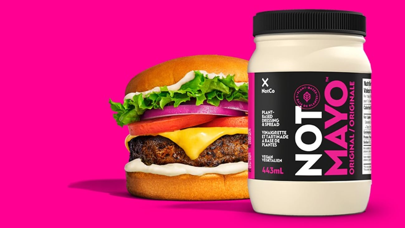 A tub of NotMayo in front of a burger