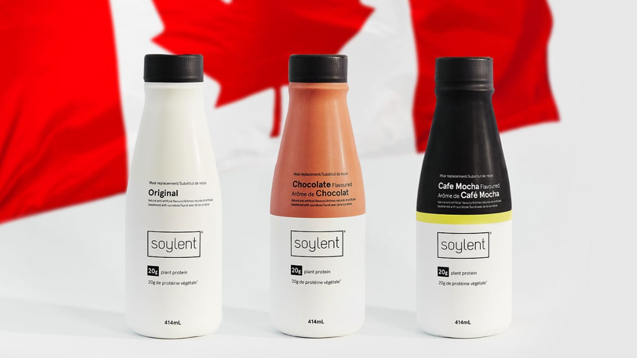 Bottles of Soylent meal replacement shakes against a Canadian flag backdrop