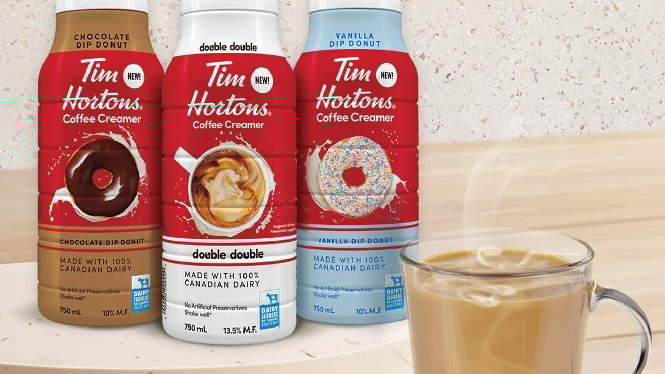 Tim Hortons coffee creamers on a table next to a cup of coffee