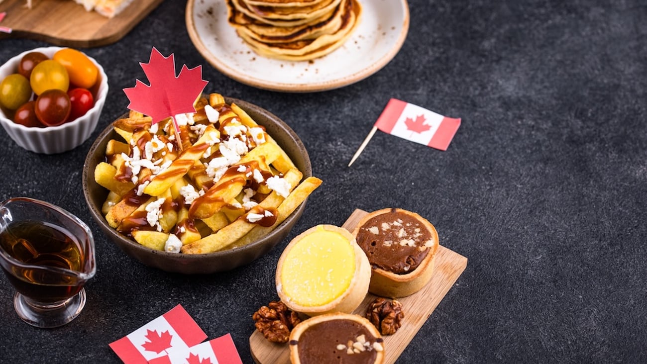 A spread of Canadian foods poutine, pancakes, tarts and maple syrup 
