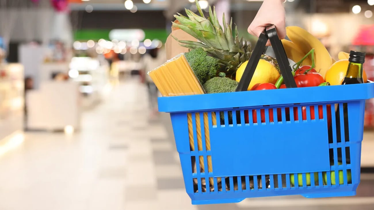 Customer holding shopping basket with different food products at supermarket, closeup. Banner design; Shutterstock ID 2704474369