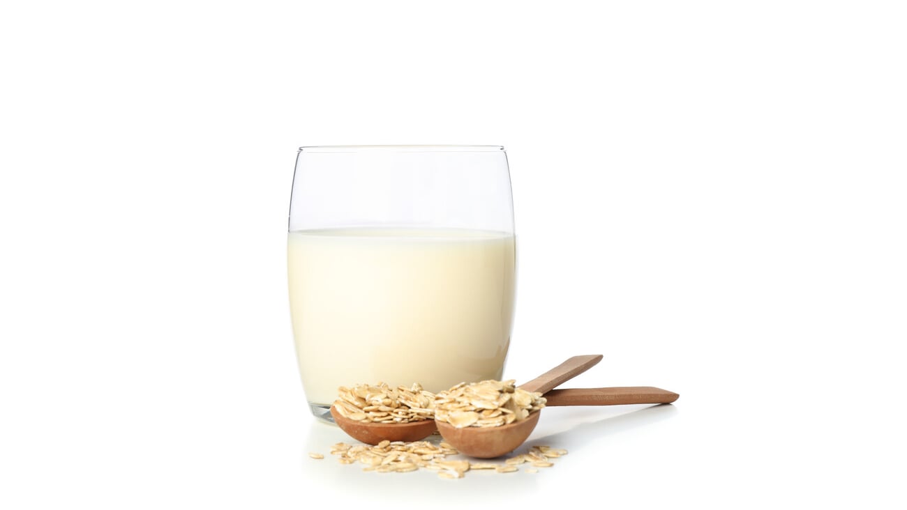 Oat milk and oatmeels in spoon isolated on white background; Shutterstock ID 1578926686