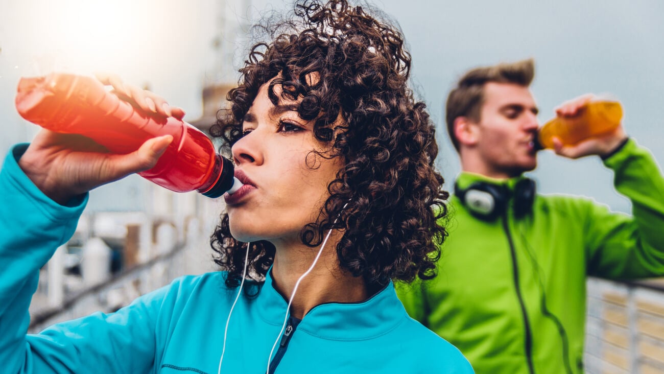 Hispanic runner woman drinking energy drink outdoor ; Shutterstock ID 1838500882