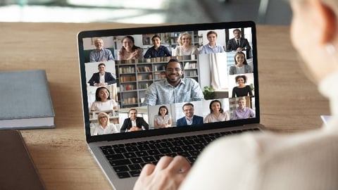 A female sitting on her laptop having a Zoom call with her coworkers