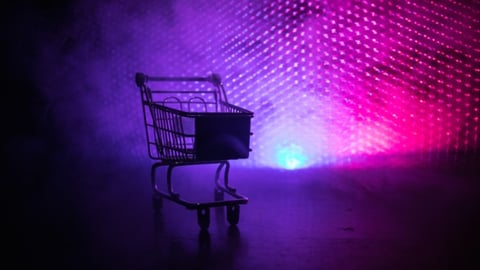 Empty shopping trolley on dark toned foggy background. 