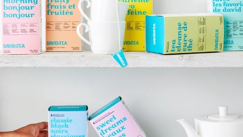 A shelf of DavidsTea boxes, tea cups and tea pot