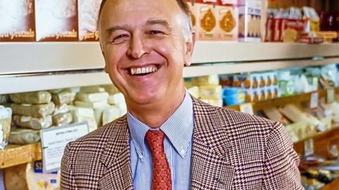 Trader Joe's founder Joe Coulombe standing in front of a grocery shelf