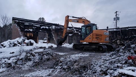 Bulldozer collecting debris from a fire that gutted a local grocery store