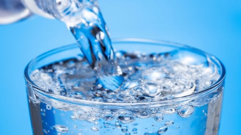 Bottle of carbonated water being poured into a glass