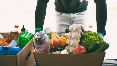 The courier takes the cardboard eco box with products from grocery shop out from the van