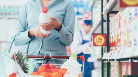 Woman doing grocery shopping at the supermarket and reading food labels, nutrition and quality concept