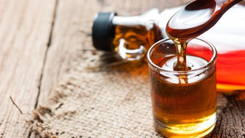 maple syrup in glass bottle on wooden table