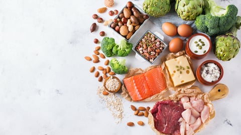 Assortment of healthy protein source and body building food. Meat beef salmon chicken breast eggs dairy products cheese yogurt beans artichokes broccoli nuts oat meal. Copy space background, top view