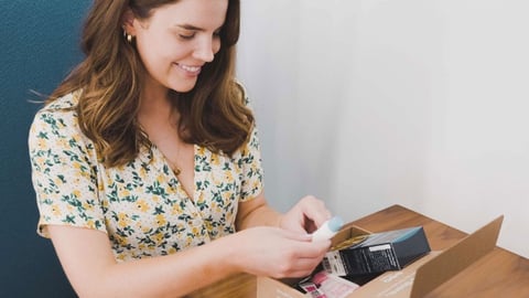 A female consumer opening her Sampler box of samples