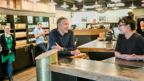 Howard Schultz speaks to a barista in a Starbucks store