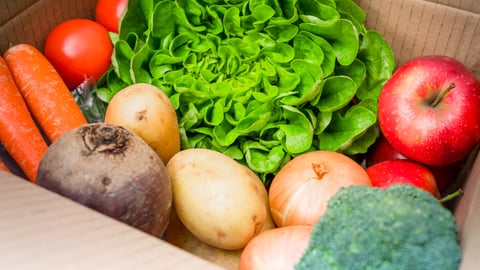 Cardboard delivery box filled with fresh fruit and vegetables