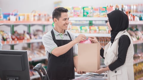 asian muslim woman buying some halal product at supermarket