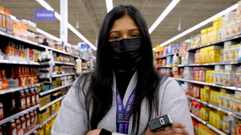 Walmart associate in the grocery aisle wearing a ring scanner