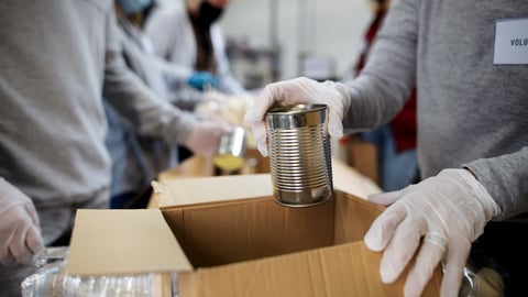 Midsection of group of volunteers in community donation center, food bank and coronavirus concept.