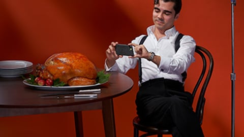 A man sitting at a table with a turkey