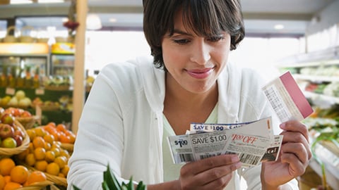 A woman holding a handful of coupons