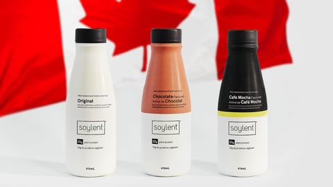 Bottles of Soylent meal replacement shakes against a Canadian flag backdrop
