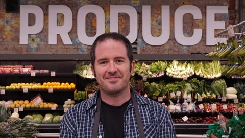 Grocer Digs Dorfman standing in the produce section of his store
