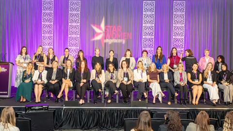 Star Women winners sitting on stage with their trophies
