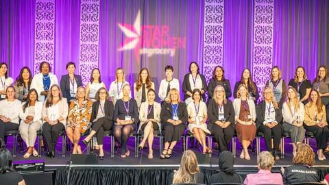Star Women in Grocery winners sitting on stage with their trophies