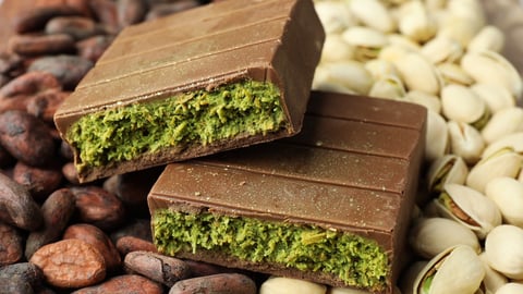 Close up of Dubai chocolate with knafeh, pistachios and cocoa beans