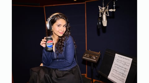 Alessia Cara in a music booth holding a can of Pepsi. Super Bowl LX 