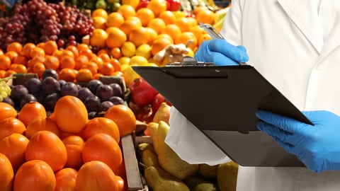 Food quality control specialist examining fruits at market, closeup
