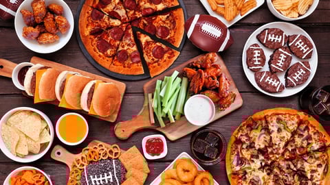 A spread of chips, wings, burgers and other game day snacks 