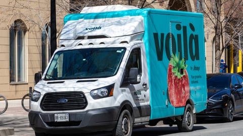 A grocery home delivery truck on a downtown city street for the Canadian Sobeys grocery store chain under the Voila brand