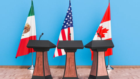 Mexican, U.S. and Canadian flags behind podiums