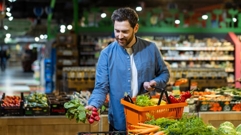 man buying vegetables at grocery store