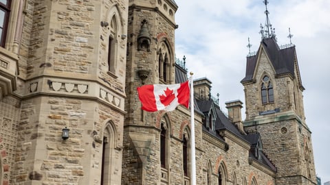 Canadian flag waving near the Parliament Hill building in Ottawa