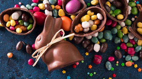 Delicious chocolate easter eggs ,bunny and sweets on dark blue background; Shutterstock ID 572928112