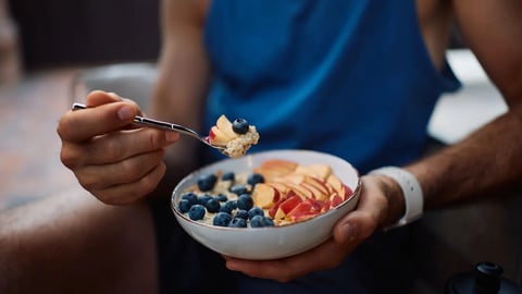 Close up of sportsman having healthy fruit oatmeal after exercise class. ; Shutterstock ID 2675007961