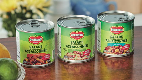 Cans of Del Monte Seasoned Bean Salads sitting on a wooden table