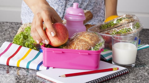 Woman preparing lunchboxes with fruits and sandwiches for school; Shutterstock ID 167098463