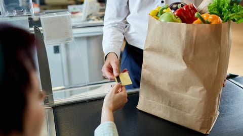 The man's hand  buyer pays by card for purchase in paper bag with healthy fresh meal near  cashier at the supermarket during shopping; Shutterstock ID 683756188