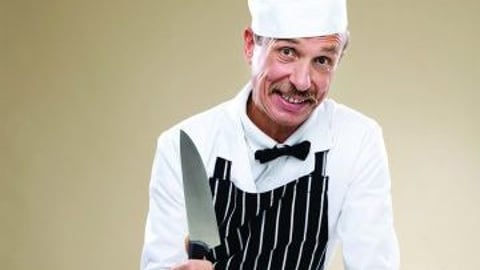 Butcher With Knife And Variety Of Sausages