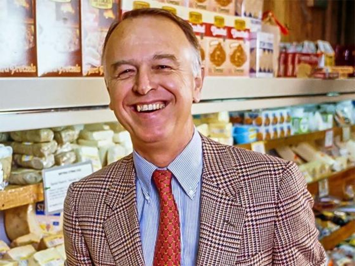 Trader Joe's founder Joe Coulombe standing in front of a grocery shelf