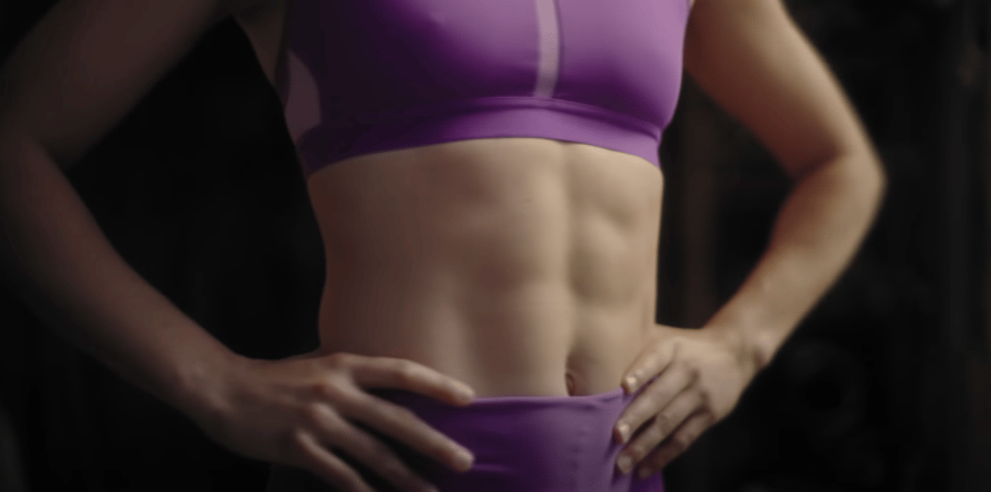 A female wearing workout gear that exposes her abs