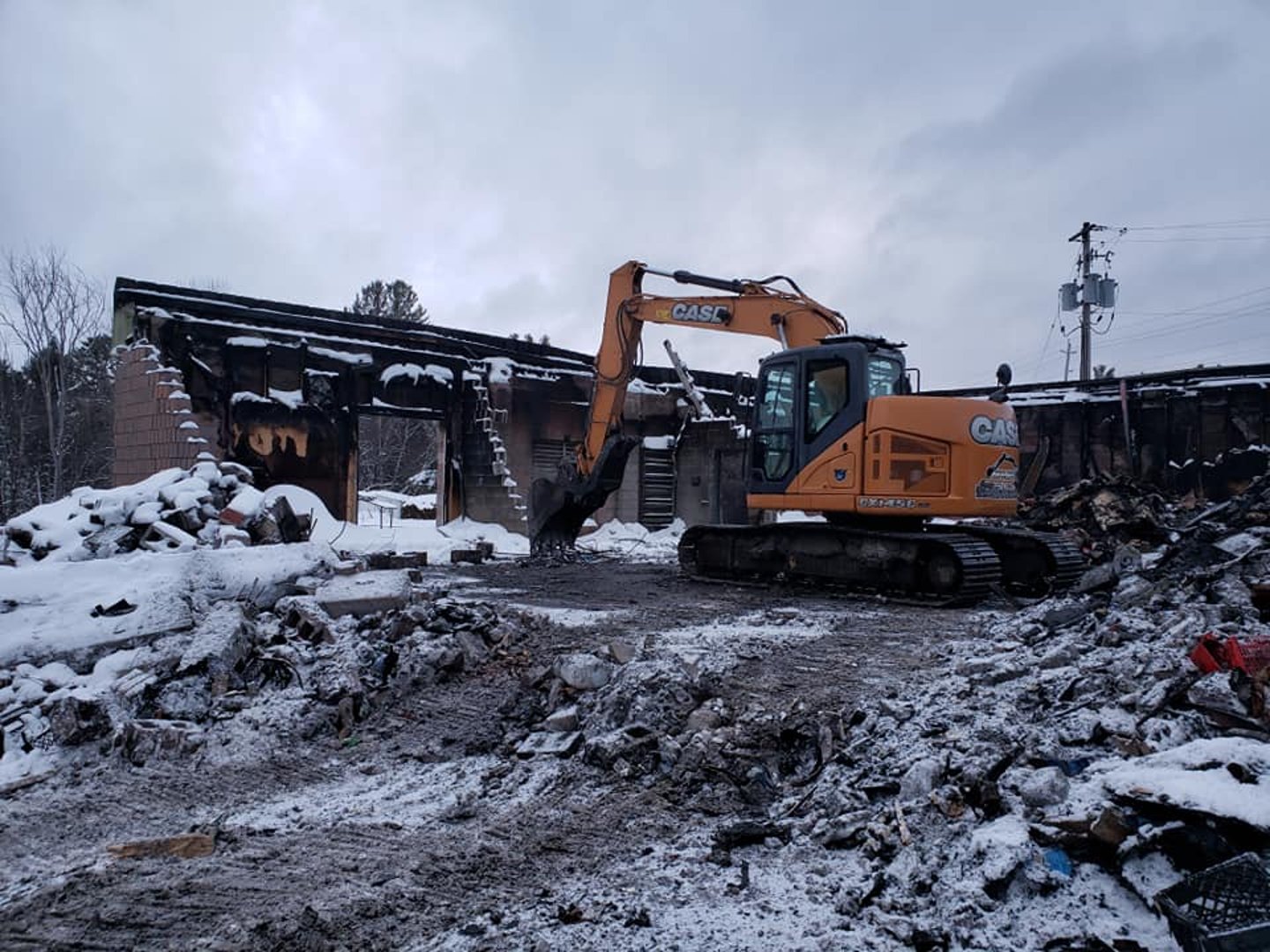 Bulldozer collecting debris from a fire that gutted a local grocery store