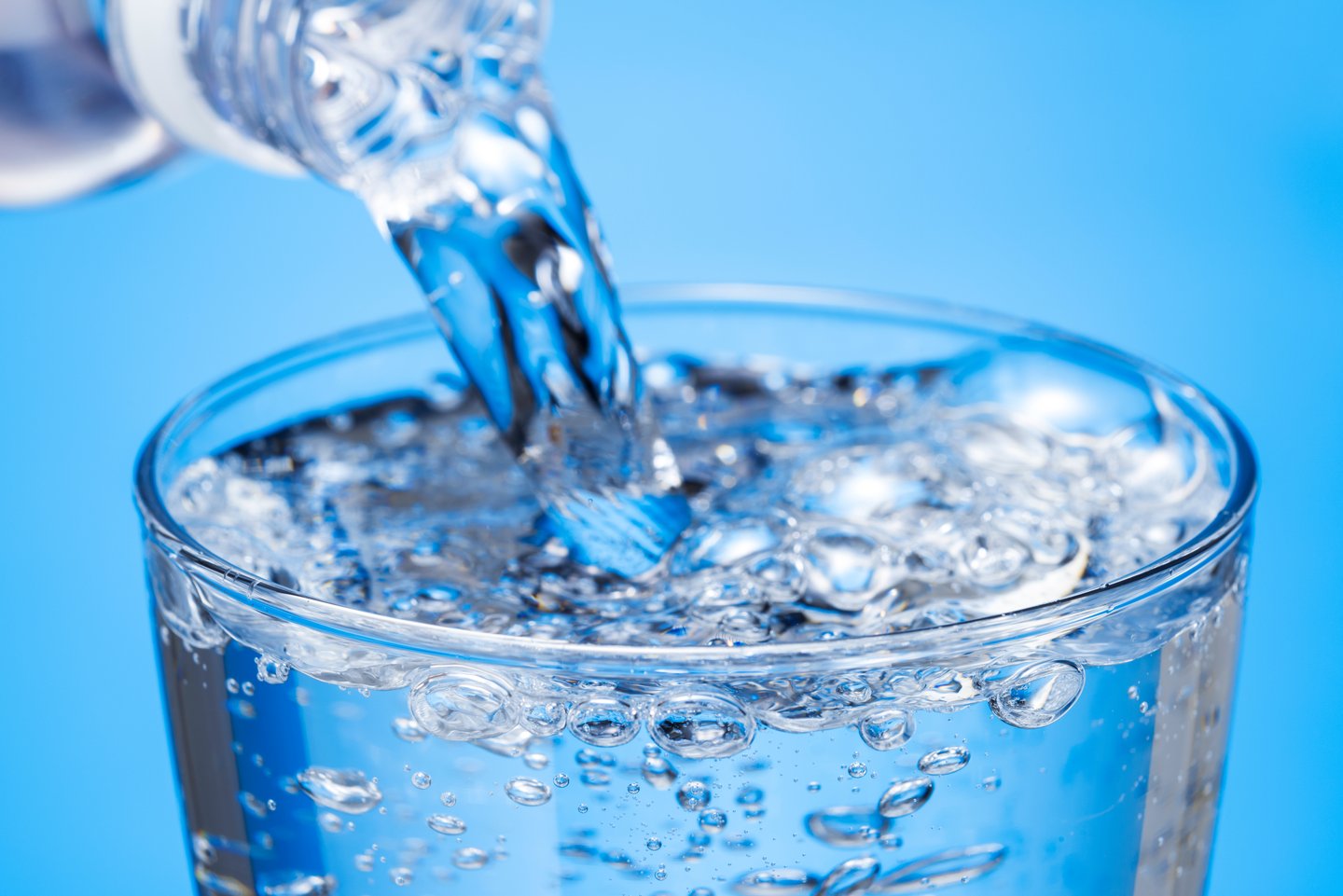 Bottle of carbonated water being poured into a glass