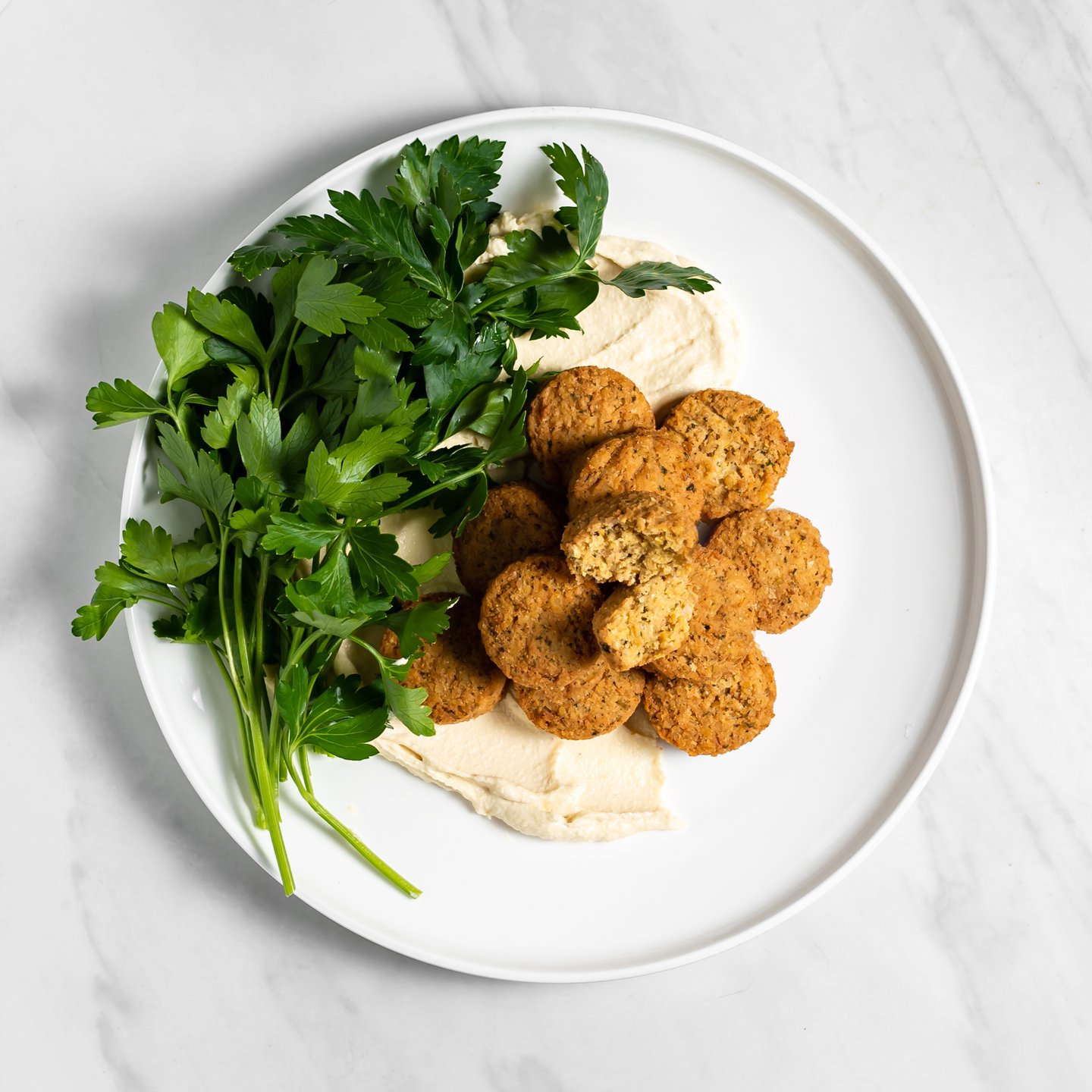 Tabule falafel served with tahini and a sprig of parsley