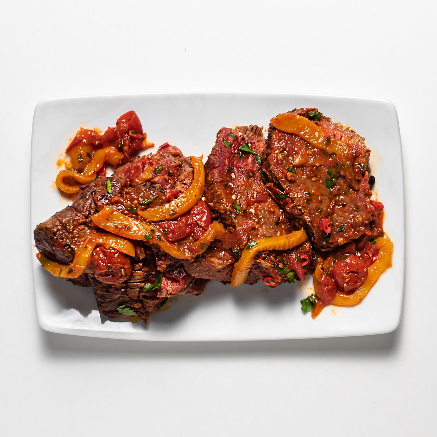 Harissa and preserved lemon beef tenderloin cooked in a red sauce.